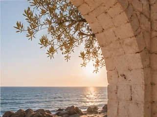 Sunset over the sea through a stone arch
